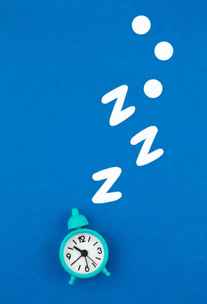 Ronquidos reloj despertador clásico sobre fondo azul pastel de moda. Piso laico, vista superior maqueta hasta —  Fotos de Stock