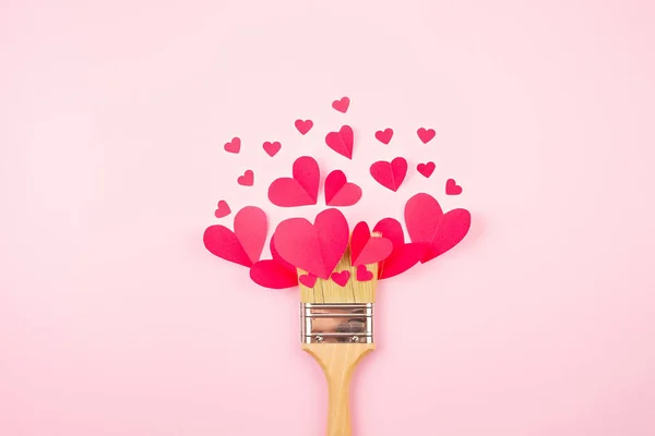 Бумажные сердца и кисть краски на розовом пастельном фоне. Love, Sainte Valentine, mother 's day, birthday cards, invitation, celebration concept — стоковое фото