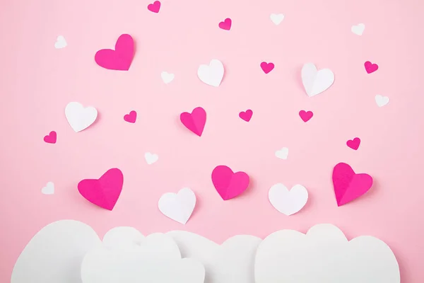 Corazones de papel y nubes sobre fondo rosa. Amor, San Valentín, día de la madre, tarjetas de felicitación de cumpleaños, invitación, concepto de celebración — Foto de Stock