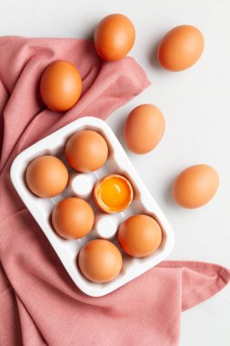 Yumurtalar, arka planda kırsal tarzda havlu. Organik bileşen, sağlıklı gıda yaşam tarzı konsepti. Paskalya geçmişi. Düz yat, boşluğu kopyala