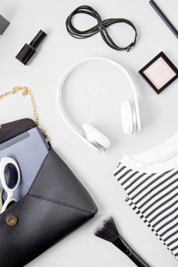 Kadın moda aksesuarları, güneş gözlükleri, not defteri, makyaj malzemesi ve siyah beyaz renkli el çantası. Güzellik, kentsel kıyafet ve moda konsepti