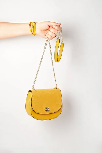 Mujer mano sosteniendo accesorios de moda femenina amarilla, bolso de mano. Belleza, compras, atuendo urbano y tendencias de la moda —  Fotos de Stock