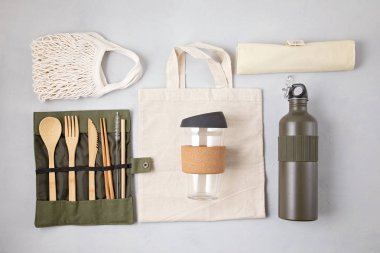 Sıfır atık. Çevre dostu bambu çatal bıçak takımı, ağ pamuk torbası, yeniden kullanılabilir kahve bardağı ve su şişesi. Sürdürülebilir, etik, plastik içermeyen yaşam tarzı. 