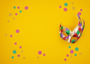 Şenlikli, renkli Mardi Gras ya da karnaval maskesi ve sarı arka planda aksesuarlar. Parti davetiyesi, tebrik kartı, Venedik karnavalı kutlama konsepti. Düz konum, üst görünüm, kopyalama alanı