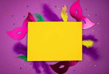 Şenlikli, renkli Mardi Gras ya da karnaval maskesi ve aksesuarları mor arka planda. Parti davetiyesi, tebrik kartı, Venedik karnavalı kutlama konsepti. Düz konum, üst görünüm, kopyalama alanı