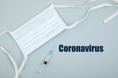 Coronavirus 2019 ncov metni, tek kullanımlık tıbbi maske, kişisel koruyucu ekipman, şırınga dolu ilaç ya da aşı ve ilaç hapları. Virüs konsepti