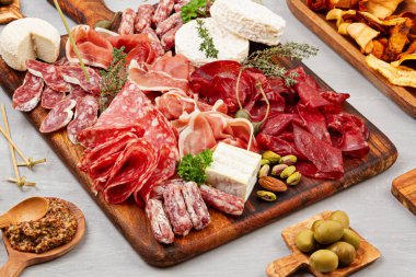 Farklı aperatifler, antipasti, şarküteri, aperatif ve şarap. Sosis, jambon, tapas, zeytin, peynir ve açık büfe partisi için kraker. Üst manzara, düz uzanma