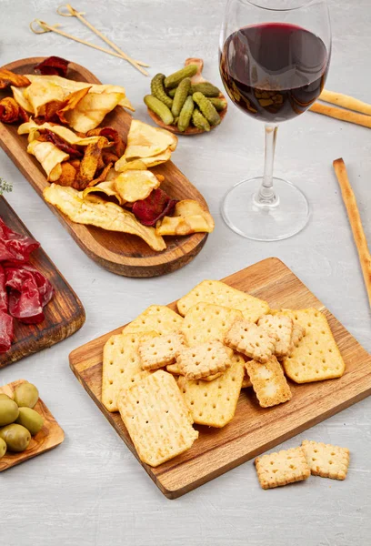 Appetizers table with differents antipasti, charcuterie, snacks and wine. Sausage, ham, tapas, olives, cheese and crackers for buffet party. Top view, flat lay