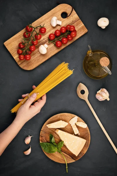 Puesta Plana Mano Mujer Sosteniendo Espaguetis Ingredientes Para Cocinar Pasta — Foto de Stock