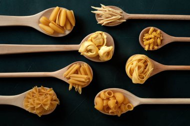 Geleneksel İtalyan makarnasının farklı türleriyle yatıyordu. Penne, tagliatelle, fusilli, farfalle, spagetti ve diğerleri. Geleneksel italyan kümes konsepti. Üst görünüm