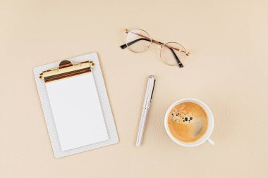 Not defteri ve gözlüklerle en üstteki görünüm. Ev ofisi, iş kadını, şık çalışma alanı konsepti. Düz yat, model al.