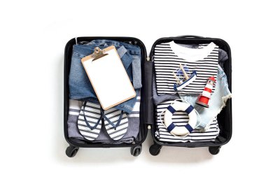 Beyaz arka planda yaz tatili için açık bavul ve günlük kıyafetlerle yatıyordu. Yaz tatili, seyahat, turizm, uçuş valizi konsepti. Üst görünüm