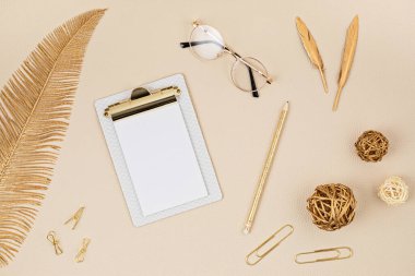 Not defteri, gözlük ve altın aksesuarlarla masaüstü görüntüsü. Ev ofisi, iş kadını, şık çalışma alanı konsepti. Düz yat, model al.