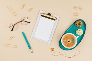 Not defteri, gözlük ve altın aksesuarlarla masaüstü görüntüsü. Ev ofisi, iş kadını, şık çalışma alanı konsepti. Düz yat, model al.