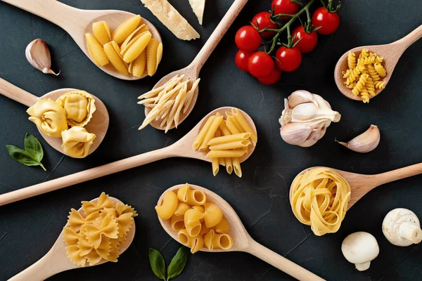 Geleneksel İtalyan makarnasının farklı türleriyle yatıyordu. Penne, tagliatelle, fusilli, farfalle, spagetti ve yemek malzemeleri. Geleneksel italyan kümes konsepti. Üst görünüm