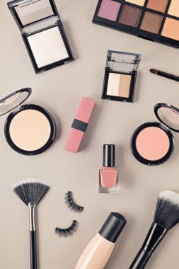 Profesyonel dekoratif kozmetik setleri, makyaj aletleri ve gri arka planda fotokopi alanı olan kadın aksesuarlarıyla yatıyordu. Güzellik blogu, moda, parti ve alışveriş konsepti. Üst görünüm