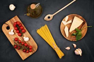 İtalyan makarnası pişirmek için gerekli malzemeler. Spagetti, domates, yağ, sarımsak, parmezan. Geleneksel italyan kümes konseptinin en üst görüntüsü