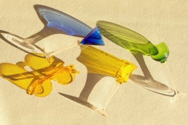 Deri desenli arka planda yaz modasına uygun likör bardaklarının üst görüntüsü. Yaz tatili, parti, moda, eğlence konsepti