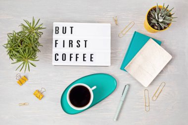 Işık kutusuyla yatıyordu ama önce kahve ve kahve fincanı vardı. Sosyal medya, feminen blog, iş sabahı konsepti. Üst görünüm