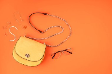 Düz yatıyordu kadın moda aksesuarlarıyla turuncu deri kaplamalı arka planda sarı renkli. Moda, çevrimiçi güzellik blogu, yaz stili, alışveriş ve trend konsepti