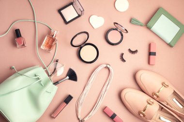Profesyonel dekoratif kozmetik setiyle, makyaj aletleriyle ve kadın baharıyla yatıyordu. Pembe arka planda fotokopi alanı olan yaz aksesuarları. Güzellik blogu, moda, parti, alışveriş konsepti. Üst görünüm
