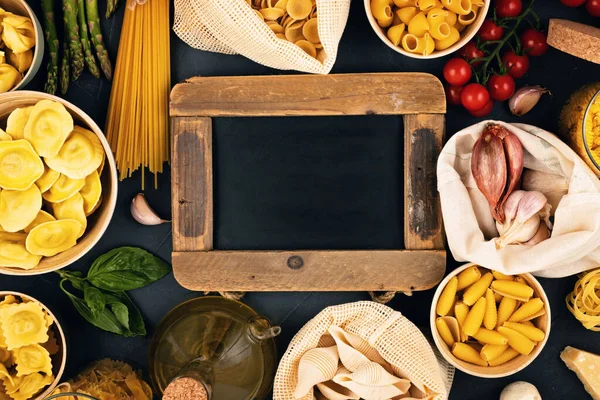 Flat lay with tradiotional organic italian pasta and cooking ingredients in reusable cotton bags and glass containers. Zero waste, plastic free concept