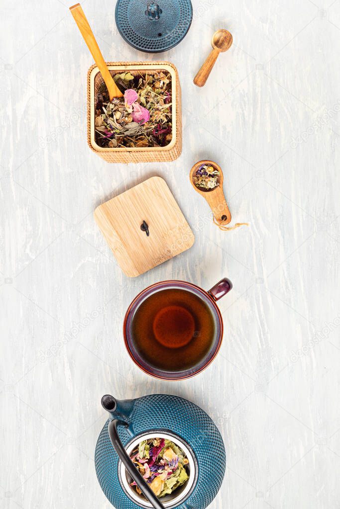 Traditional tea ceremony accessories, teapot and teacup with herbs and dry fruits tea. Destressing, relaxation, healing, healthy comforting, tea time concept. Top view, flat lay  