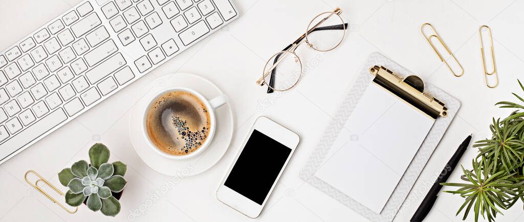 Top view of office desk. Table with keyboard, smartphone, clipboard and office supplies. Flat lay home office workspace, remote work, distant learning, video conference, calls idea. Banner 