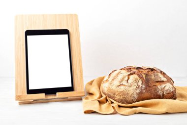 Taze organik ev yapımı ekmek ve fotokopi alanı olan not defteri. Sağlıklı beslenme, pişirme uygulaması, online ekmek tarifleri konsepti. Model