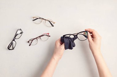 Kadın el temizleme gözlükleri. Optik mağaza, gözlük seçimi, göz testi, göz doktorunda vizyon muayenesi moda aksesuarları konsepti. Üst manzara, düz uzanma