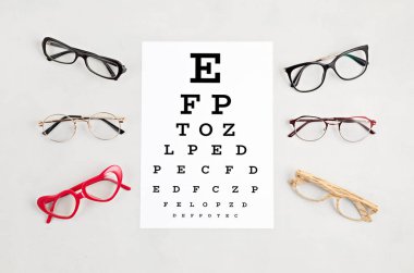 Gözlük koleksiyonu ve göz testi masası. Optik mağaza, gözlük seçimi, göz testi, göz doktorunda vizyon muayenesi moda aksesuarları konsepti. Üst manzara, düz uzanma