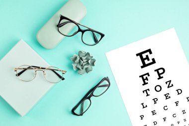 Gözlük koleksiyonu ve göz testi masası. Optik mağaza, gözlük seçimi, göz testi, göz doktorunda vizyon muayenesi moda aksesuarları konsepti. Üst manzara, düz uzanma