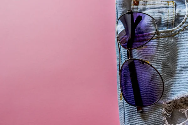 Modré džínové kraťasy s mobilní andsunglasses v kapsách, — Stock fotografie