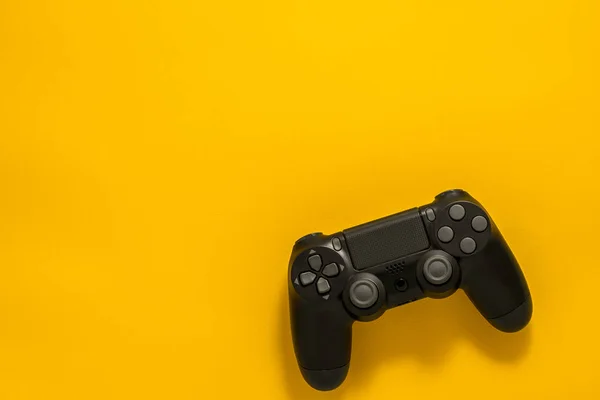 黄色の背景に黒のゲームパッド ゲームのコンセプト フラット レイアウト Copyspace — ストック写真
