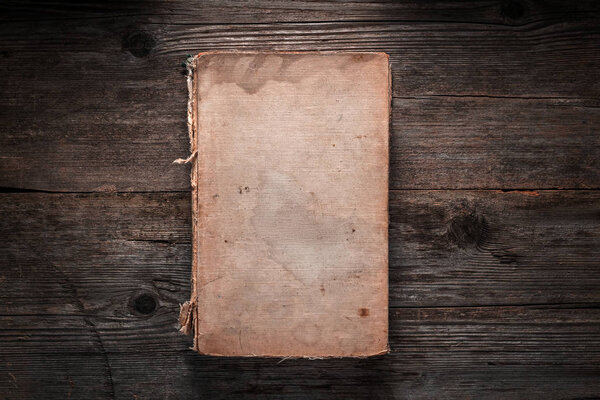 Closed book on vintage wooden background.  Old book on the woode