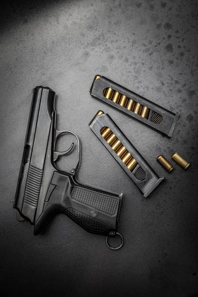 Een modern zwart pistool en munitie op donkere metalen achtergrond. W — Stockfoto