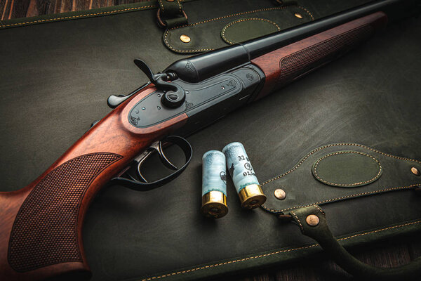 Classic trigger double-barreled hunting rifle on a green backgro