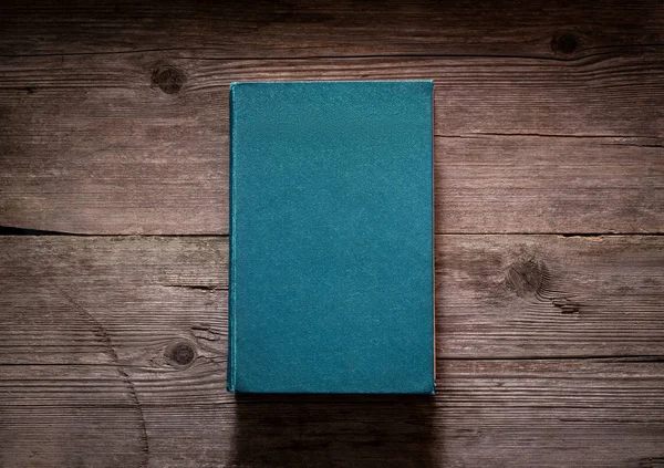 Closed book on vintage wooden background.  Old book on the woode