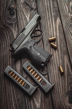 Karanlık ahşap arka planda modern siyah tabanca ve mühimmat.. 