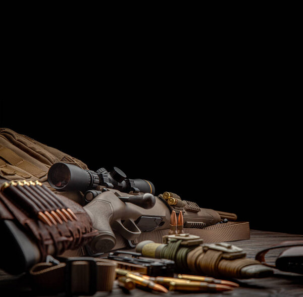 Modern bolted carbine and cartridges for it on a dark wooden tab
