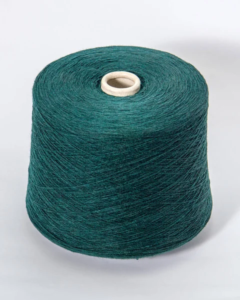 Green bobbin of yarn on a white background.Textile reel on isola — Stock Photo, Image