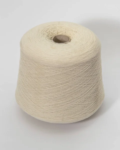 Beyaz arka plan üzerinde iplik yeşil bobin. Tekstil makara üzerinde isola