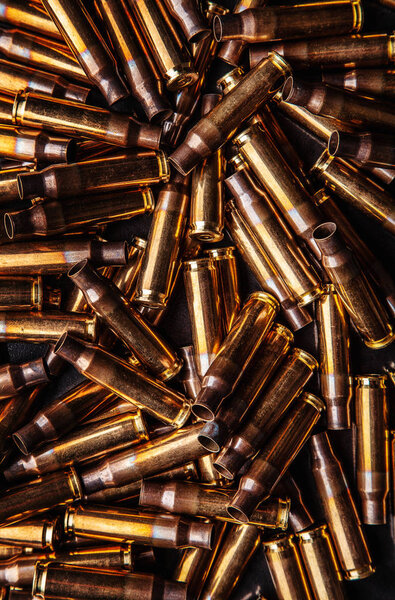 Background from empty cartridges for rifles and carbines. Shiny 