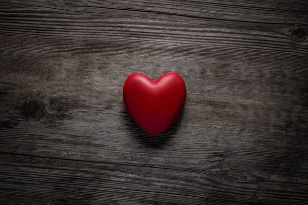 Rood hart op vintage houten achtergrond. Valentijnsdag concept. Bovenaanzicht rood hart op oude hout textuur achtergrond met kopieerruimte voor tekst. — Stockfoto