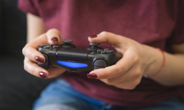 Ukraine, Odessa  July 2, 2019: A girl plays a video game on a playstation 4 joystick. The ps4 gamepad is in the girls hands. Gamer girl.