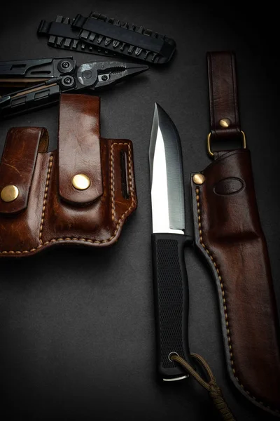 Couteau de chasse et multitool sur fond sombre. Cuir marron — Photo