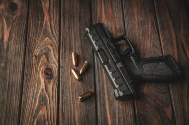 Ahşap bir arka planda modern siyah silah ve mühimmat. Tabanca.