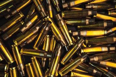 Tüfekler ve tüfekler için boş fişeklerin arka planı. Yüzeye saçılmış parlak pirinç kovanları.