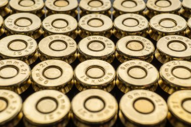 9mm 'lik bir grup yakın çekim. Fişek arkaplanı. Birbirinin yanına düzgünce istiflenmiş yeni kartuşlar.