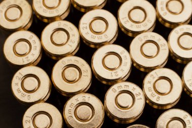 9mm 'lik bir grup yakın çekim. Fişek arkaplanı. Birbirinin yanına düzgünce istiflenmiş yeni kartuşlar.